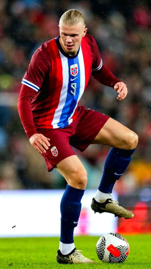 A soccer player in a red and blue Norway jersey controls a ball on the field during a match, with a blurred crowd in the background, as viewers tune in via Croatia IPTV to catch all the live action.