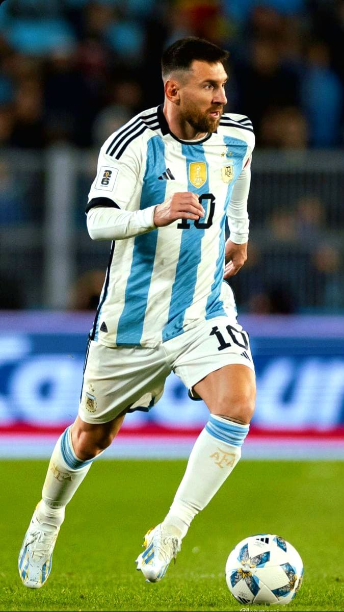 A soccer player in Argentina's national team uniform runs on the field, focused on the ball at his feet during a match, while fans around the world tune in via Croatia IPTV to catch every moment of the action.